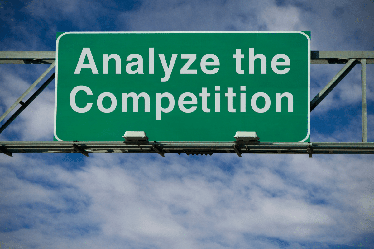 a road sign with the inscription "analyze the competition" indicating the importance of competition when it comes to SEO or social media traffic